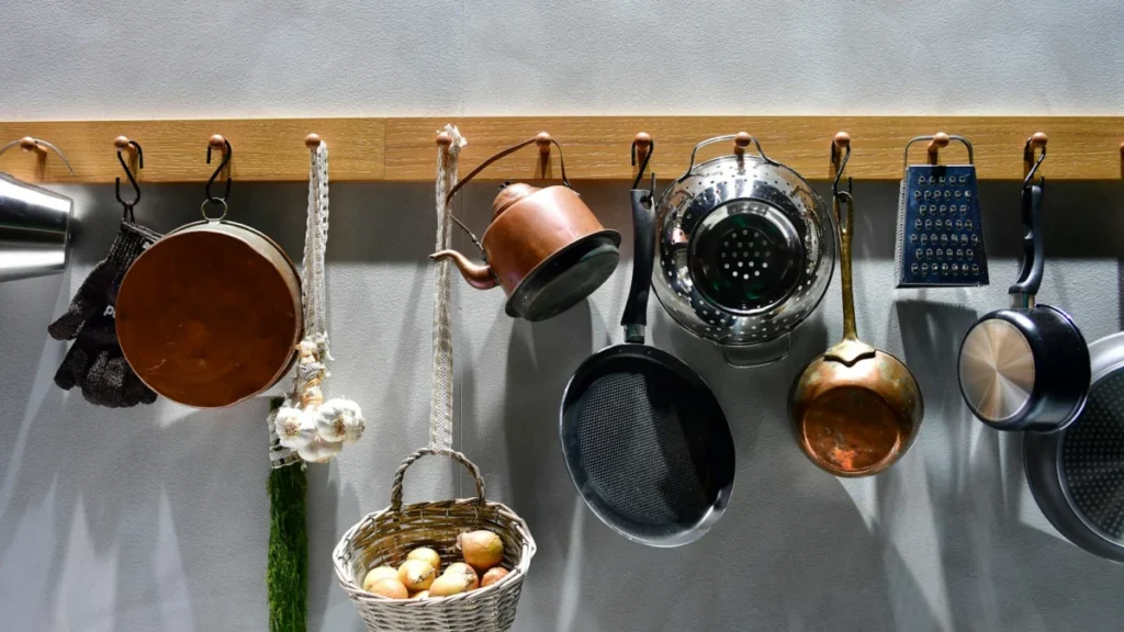 Vários utensílios de cozinha pendurados em um suporte de madeira