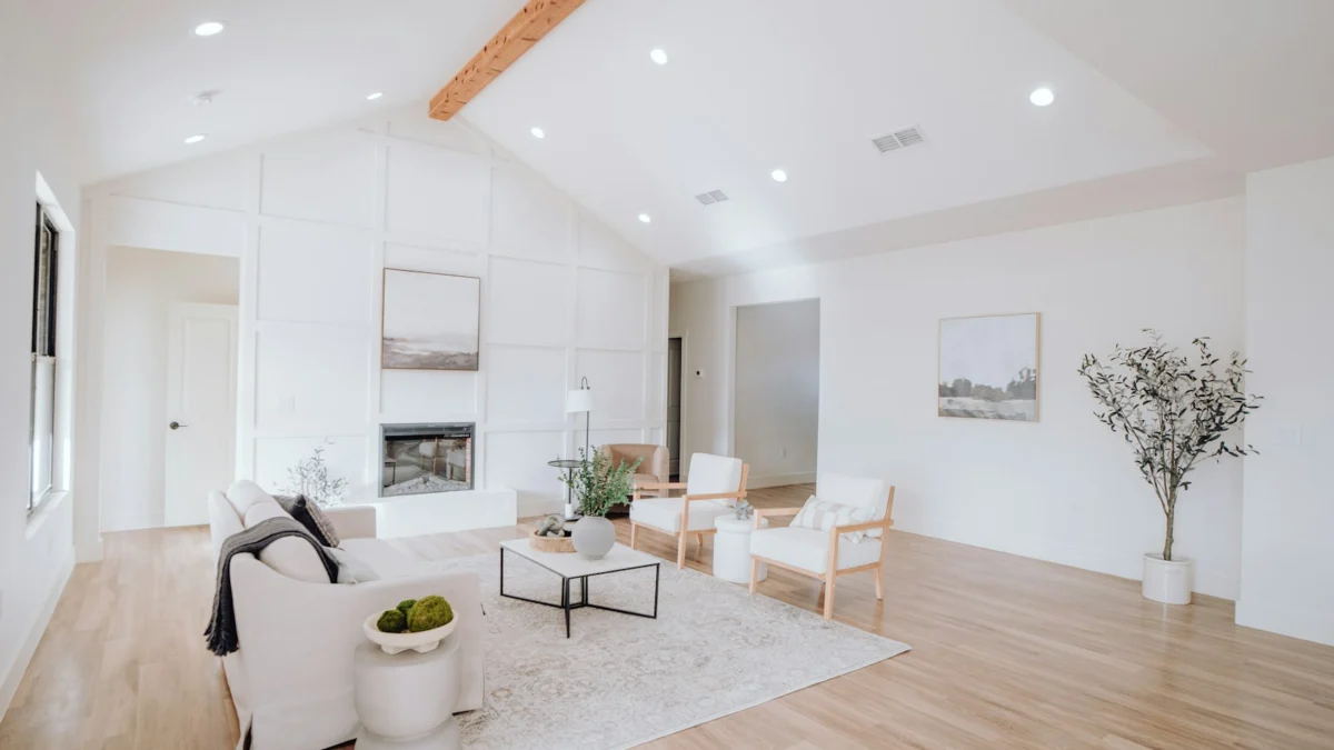 Sala de estar com móveis claros e piso de madeira