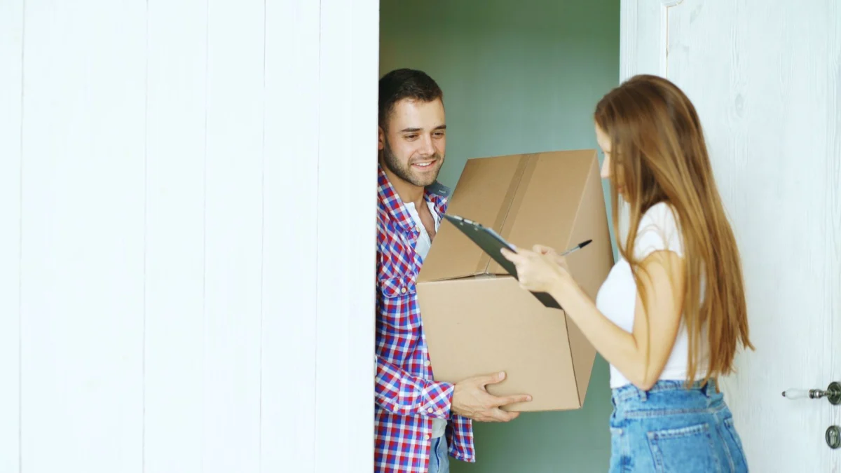Entregador entregando um pacote a uma cliente na porta