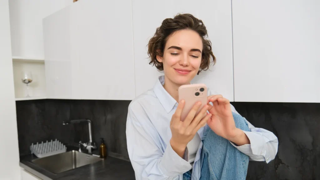Mulher sentada em casa fazendo compras em um aplicativo no celular