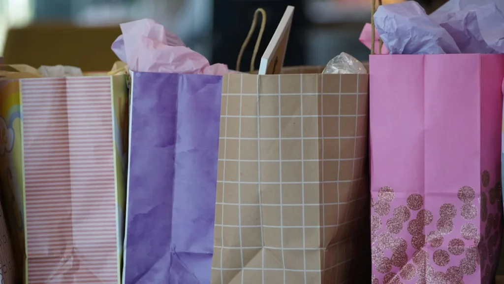 Sacolas de papel de compras nas cores roxa e branca