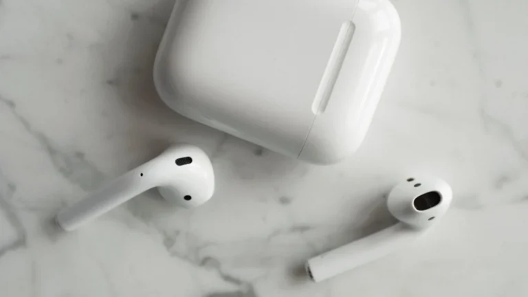 Fones de ouvido sem fio e estojo de carregamento sobre mármore
