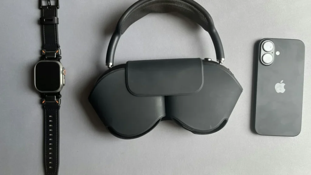 Smartwatch, fones de ouvido no estojo e smartphone sobre uma superfície cinza
