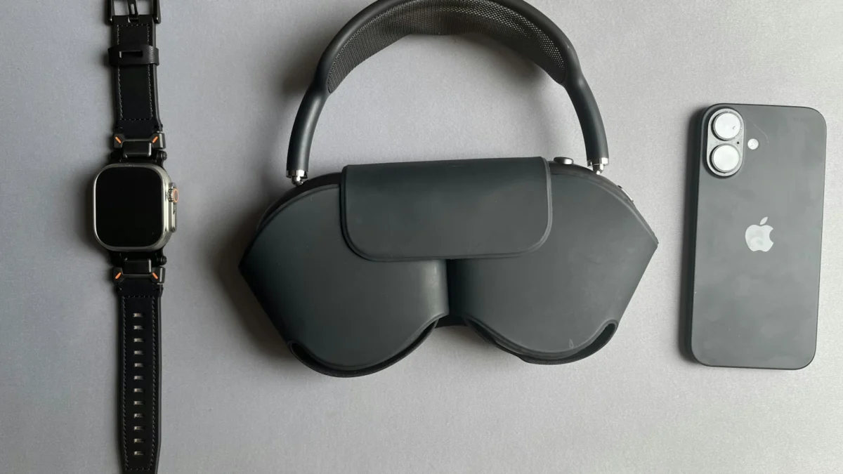 Smartwatch, fones de ouvido no estojo e smartphone sobre uma superfície cinza