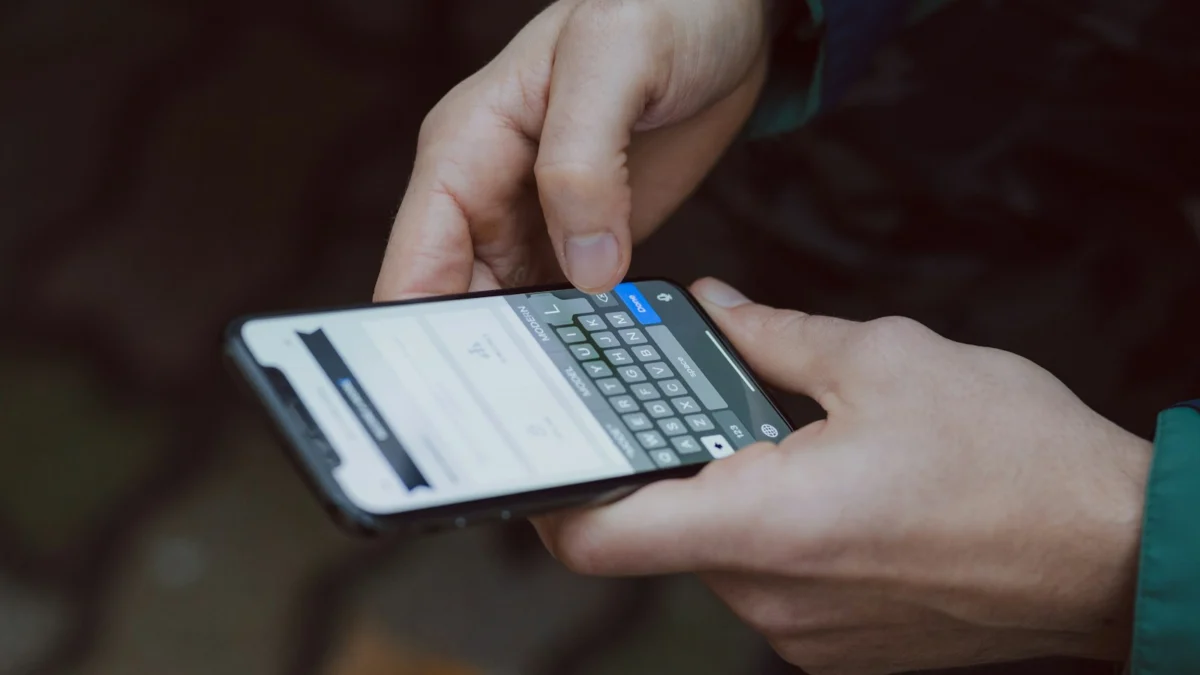 Pessoa olhando a tela do smartphone com atenção