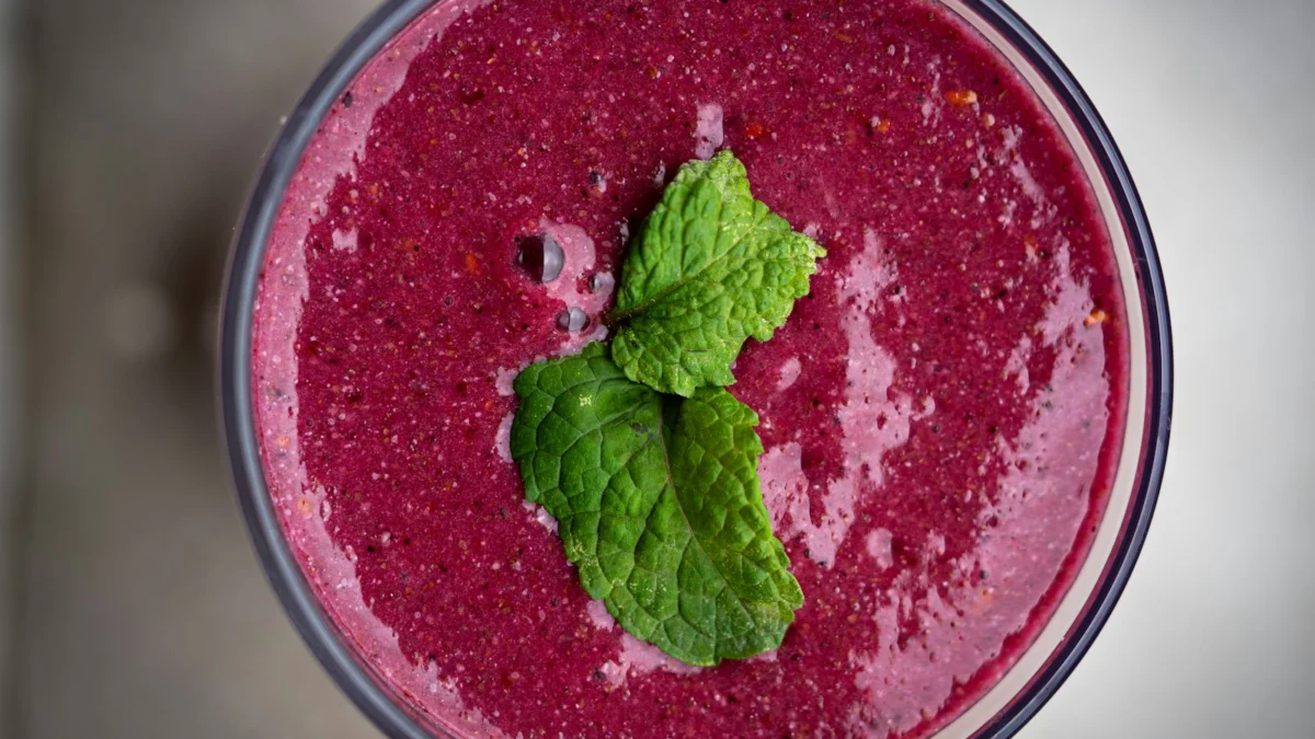 Copo de vitamina de frutas vermelhas com folhas de hortelã