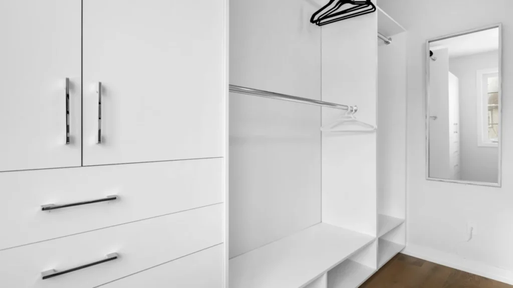 Closet com armários e gavetas brancas organizados