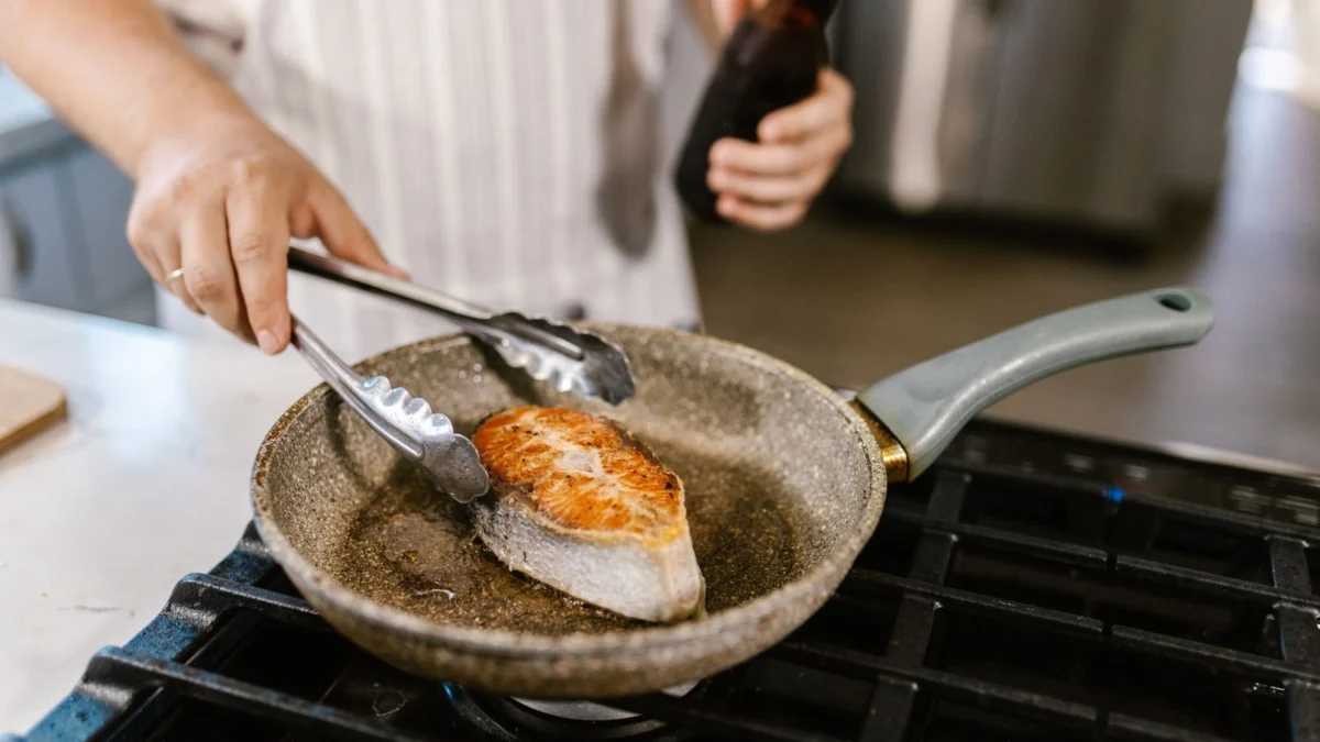 Filé de salmão sendo preparado em uma frigideira antiaderente