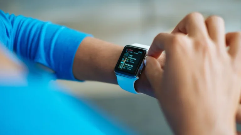 Pessoa mexendo em um smartwatch com aplicativo de exercícios na tela